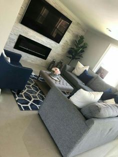 a living room filled with furniture and a flat screen tv mounted on the wall above it