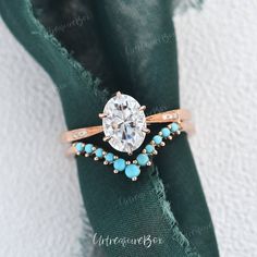 a close up of a ring on top of a green cloth with a diamond in the center