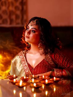 a woman sitting at a table with candles in front of her