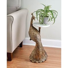 a bird shaped table with a potted plant on it's side and a couch in the background