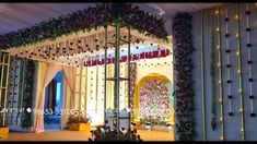 an outdoor stage decorated with flowers and greenery for a wedding ceremony at night time