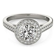 a white gold engagement ring with diamonds on the band and a round center stone in the middle