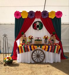 a table with flowers and decorations on it in front of a tented area for an event