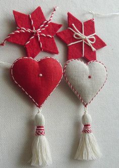 three red and white hearts with tassels hanging from strings