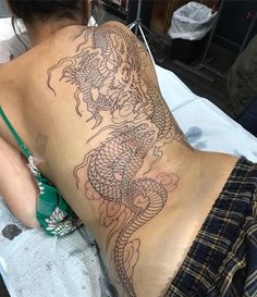 a woman with a dragon tattoo on her back