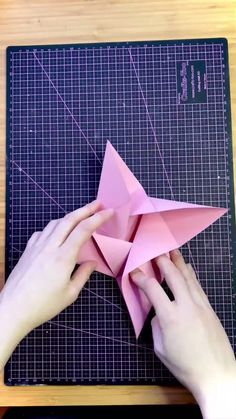 someone is cutting out an origami star