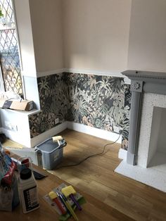 a room with wood flooring and wallpaper on the walls, including paint rollers