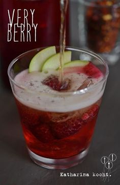 a drink being poured into a glass filled with liquid