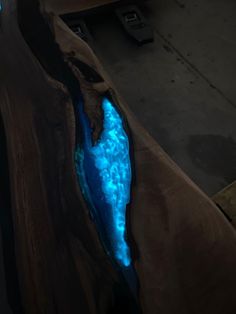 a piece of wood that has some blue light in the water on it and is sitting on top of a table