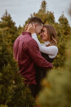 a man and woman hugging in the middle of trees