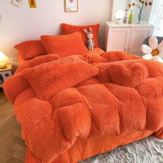 an orange comforter on a bed in a child's room with stuffed animals