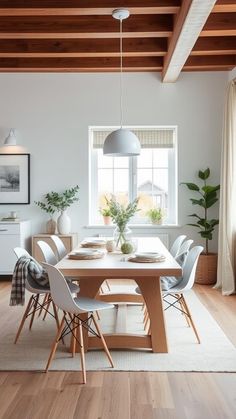 a dining room table and chairs with white walls, wooden beams and wood flooring