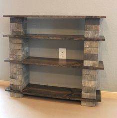 a shelf made out of wooden blocks on top of a hard wood floor next to a wall