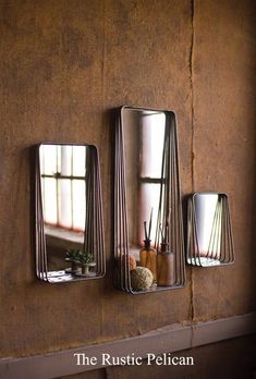 three mirrors mounted to the side of a wall