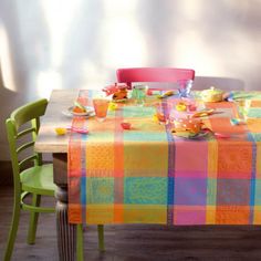 the table is set with colorful plates and cups