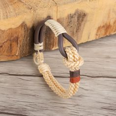 a close up of a rope bracelet on a wooden surface