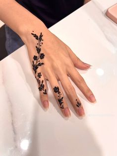 a woman's hand with black flowers on it