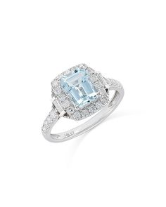 an aqua blue and white topazte ring with diamonds on the sides, set in 18k white gold