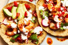 two tacos with shrimp, avocado and tomatoes