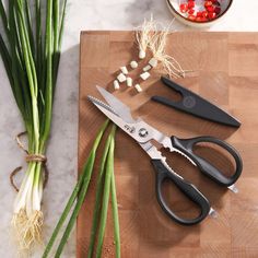 some vegetables are on a cutting board with scissors