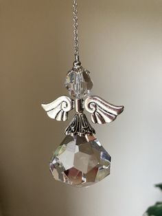 an angel ornament hanging from a chain with crystal beads and wings on it