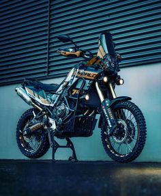 a dirt bike parked in front of a building with shutters on the wall behind it