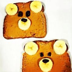 two pieces of toast with peanut butter and banana slices on them, each topped with a bear face