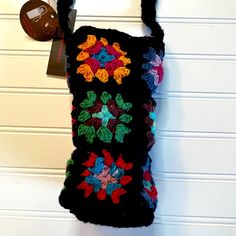 a crocheted bag hanging on a wall with a tag attached to the back