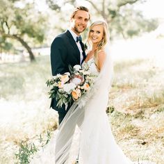 a bride and groom posing for a photo in the grass with flowers on their wedding day