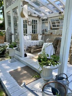 an outdoor room with potted plants on the porch