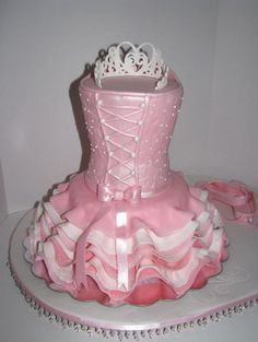 a pink and white cake with a tiara on it's top, in the shape of a corset