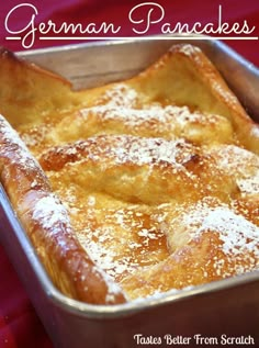 a close up of a pan of food with powdered sugar on top and the words german pancakes above it