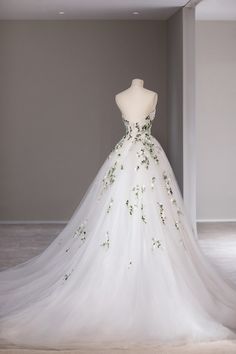 a white wedding dress with green flowers on it