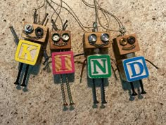 four wooden toy robots sitting next to each other on top of a table with wires