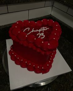 a red heart shaped cake with white frosting