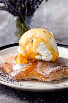 an ice cream sundae on a plate with lavenders