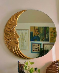 a mirror that is on the side of a wall next to a vase with flowers