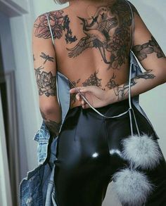 the back of a woman's body with tattoos on it