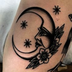 a woman's thigh with a crescent and flowers on it