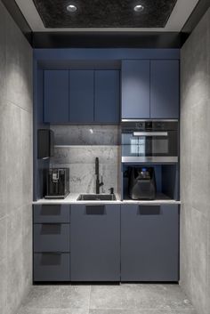 a modern kitchen with blue cabinets and marble counter tops is seen in this image from the doorway