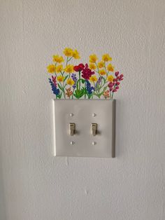 an electrical outlet with flowers painted on it