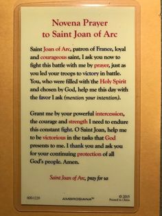 a plaque with an image of the saint joan of arc written in red on it