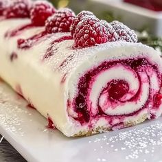 a close up of a pastry with raspberries and cream in it on a plate