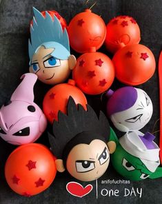 some very cute looking toys on a black surface with red and orange balls in the background