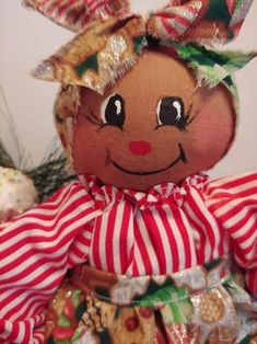 a close up of a stuffed animal wearing a red and white striped dress with christmas decorations on it