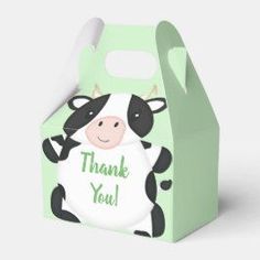 a green box with a black and white cow holding a sign that says thank you