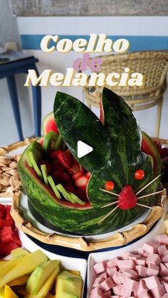 a cat made out of watermelon sitting on top of a table filled with fruit