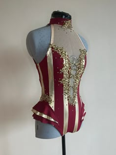 a mannequin wearing a red and gold corset with sequins