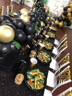 a long table with black, gold and green decorations on it at a party or event