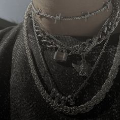 a close up of a person wearing multiple chains